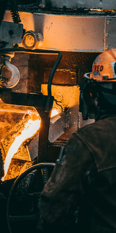 Trabajador en una fábrica trabajando con metal fundido